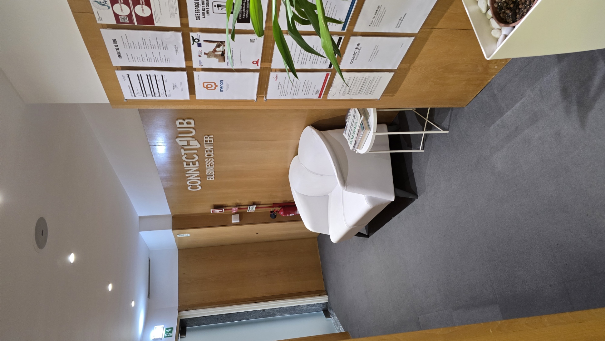 Entrada da ConnectHub com sofá branco e painel informativo