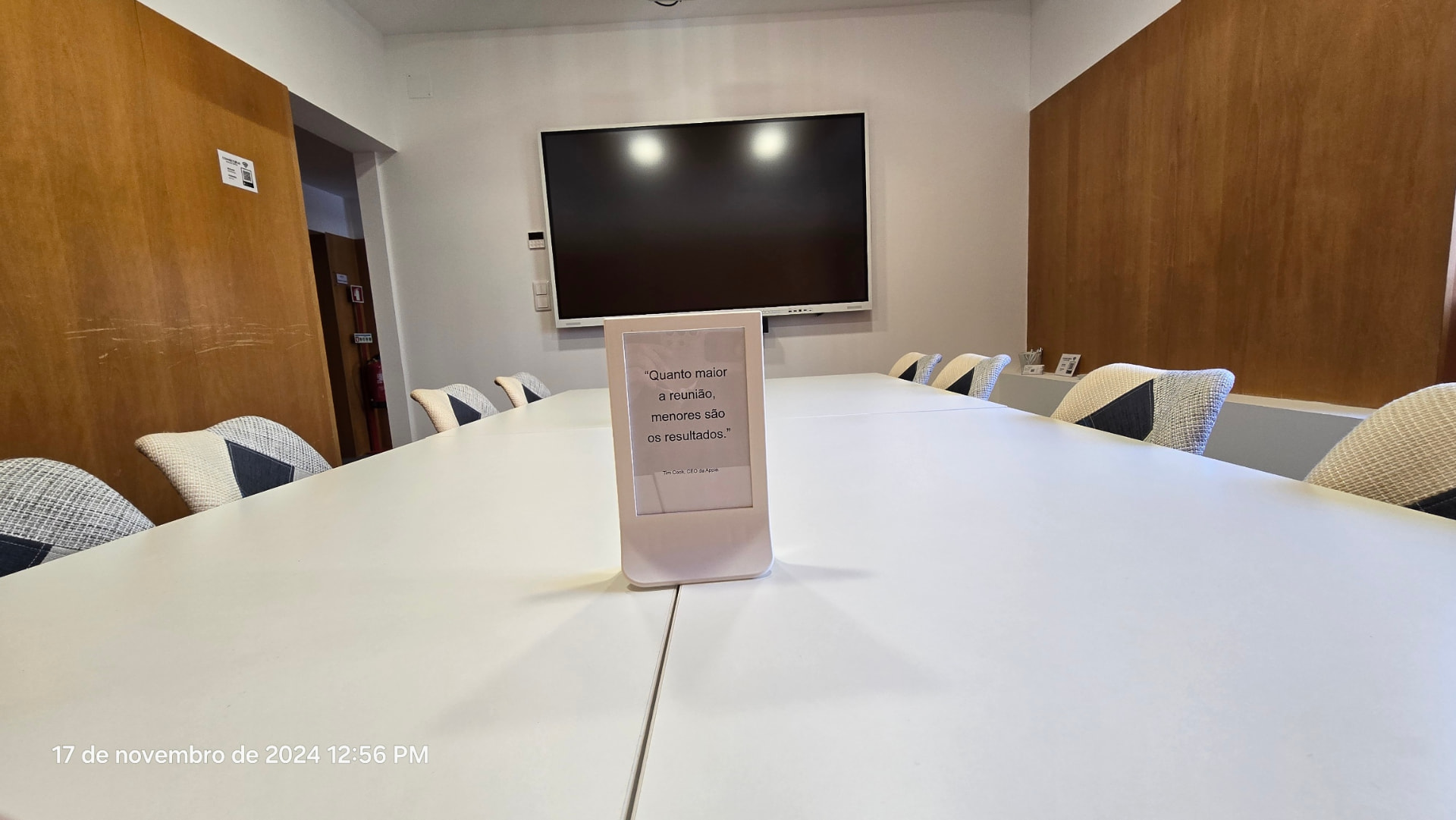 Mesa de reuniões da ConnectHub com ecrã interativo ao fundo