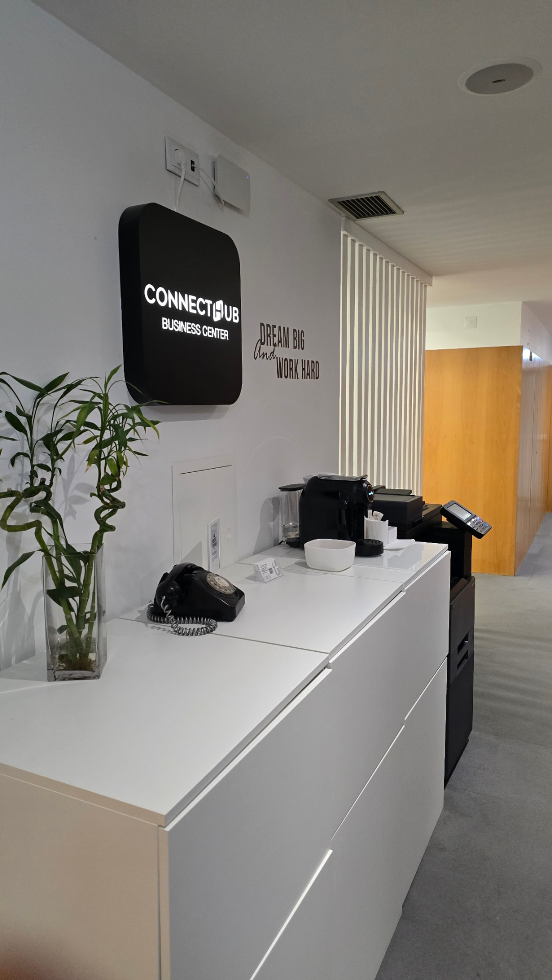 Balcão de receção da ConnectHub Business Center com sinalética iluminada