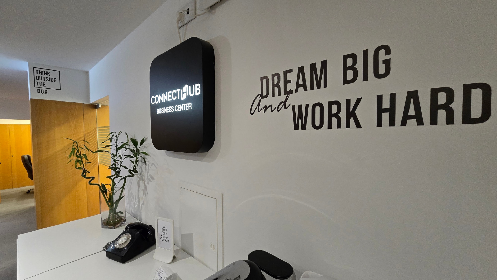 Parede da receção com o lettering Dream Big and Work Hard